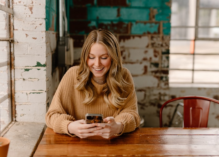 Woman at table checking phone